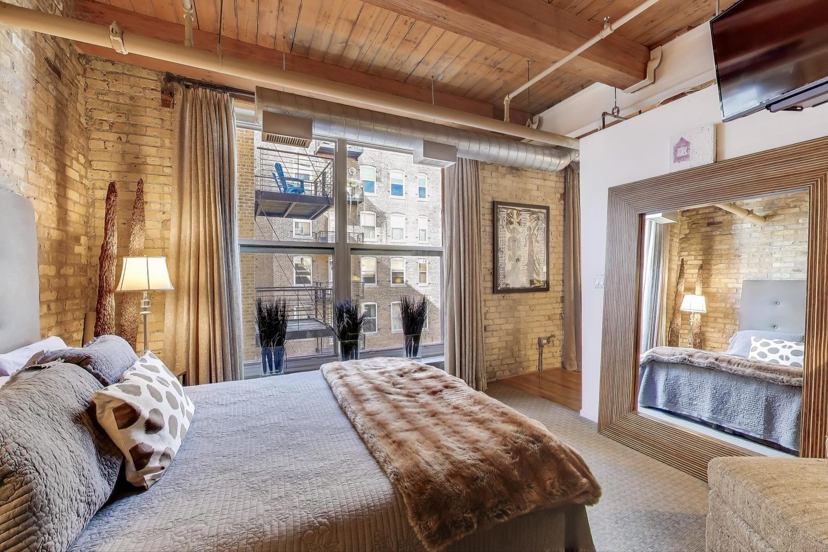 420 South Clinton Street, Unit 414A Chicago, IL 60607 - Photo 9 of 13 a bedroom with a large bed and a large window