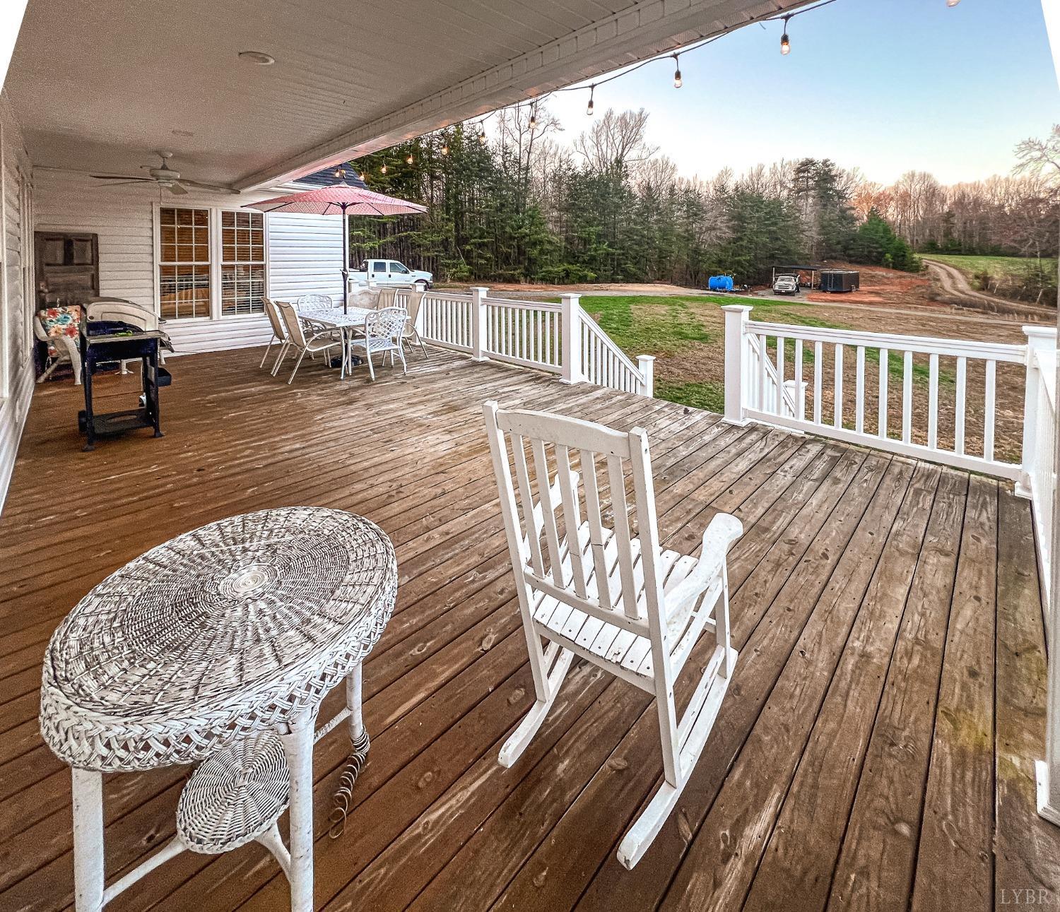 7108 Callands Road Chatham, VA 24531 - Photo 13 of 63 a view of a roof deck with table and chairs a barbeque with wooden floor and fence