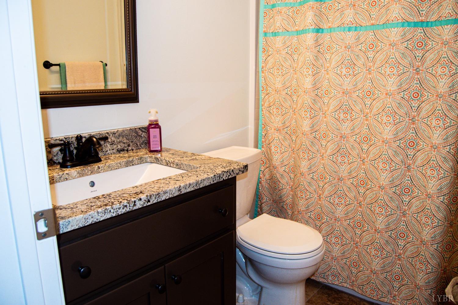 7108 Callands Road Chatham, VA 24531 - Photo 23 of 63 a bathroom with a granite countertop sink and a toilet