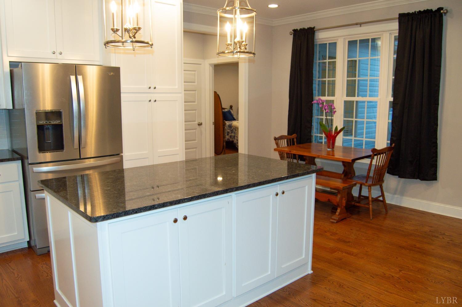7108 Callands Road Chatham, VA 24531 - Photo 29 of 63 a kitchen with stainless steel appliances granite countertop a refrigerator a stove and a dining table with wooden floor