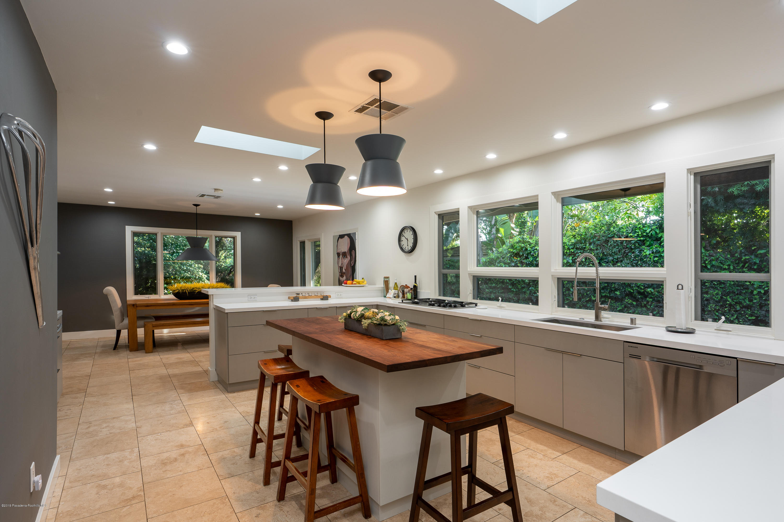 3795 Shadow Grove Road Pasadena, CA 91107 - Photo 17 of 48 a kitchen with stainless steel appliances granite countertop a stove a sink a dining table and chairs with white cabinets