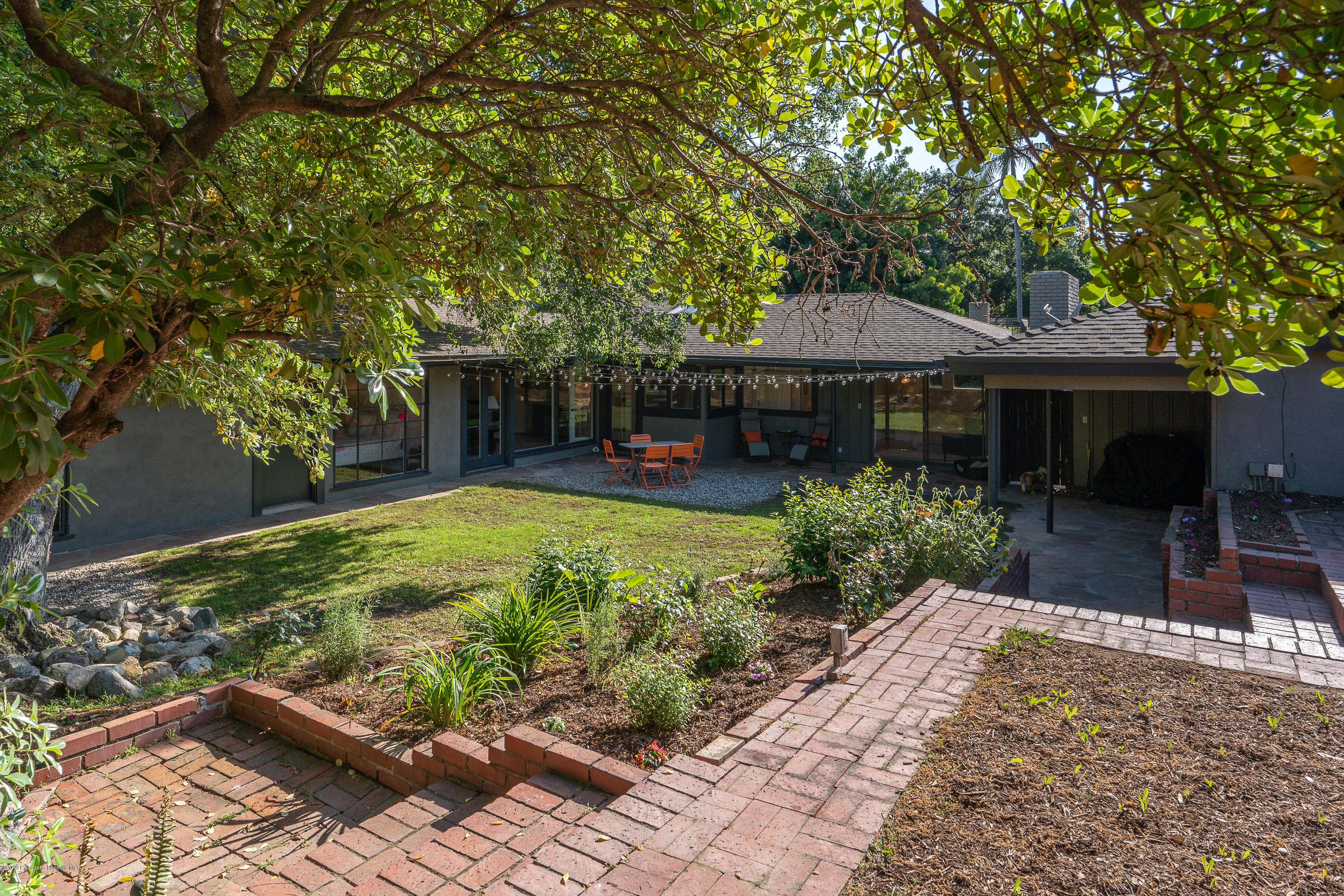 3795 Shadow Grove Road Pasadena, CA 91107 - Photo 33 of 48 a view of a patio with table and chairs under an umbrella with large trees