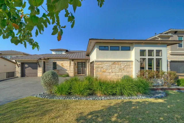 a front view of a house with a garden