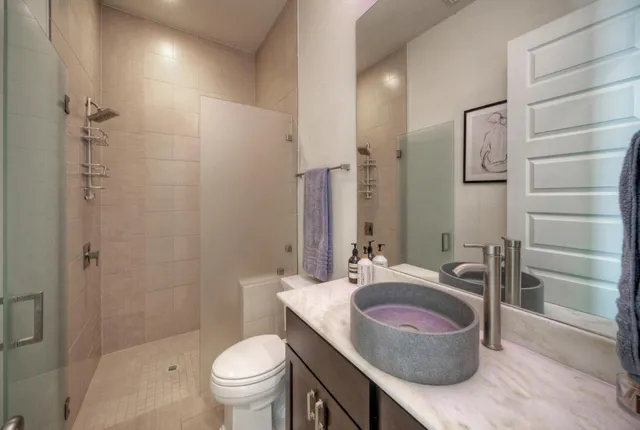 a bathroom with a sink a toilet and shower