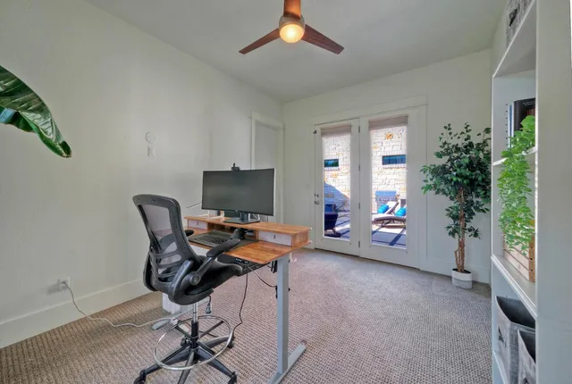 a view of a workspace with furniture and a window