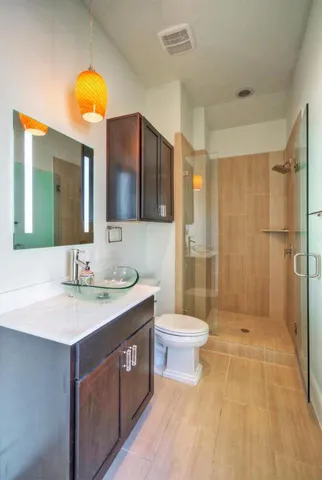 a bathroom with a sink a toilet a mirror and shower