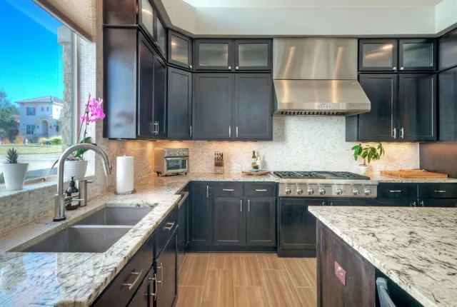a kitchen with granite countertop a sink stove and cabinets