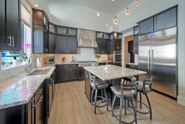 a kitchen with granite countertop kitchen island a table and chairs in it