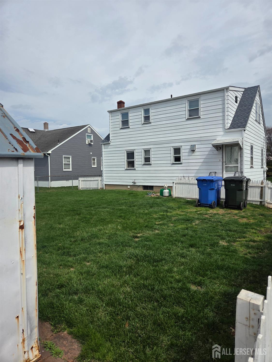 83 Daniel Street Port Reading, NJ 07064 - Photo 4 of 15 a front view of house with yard and trees in the background