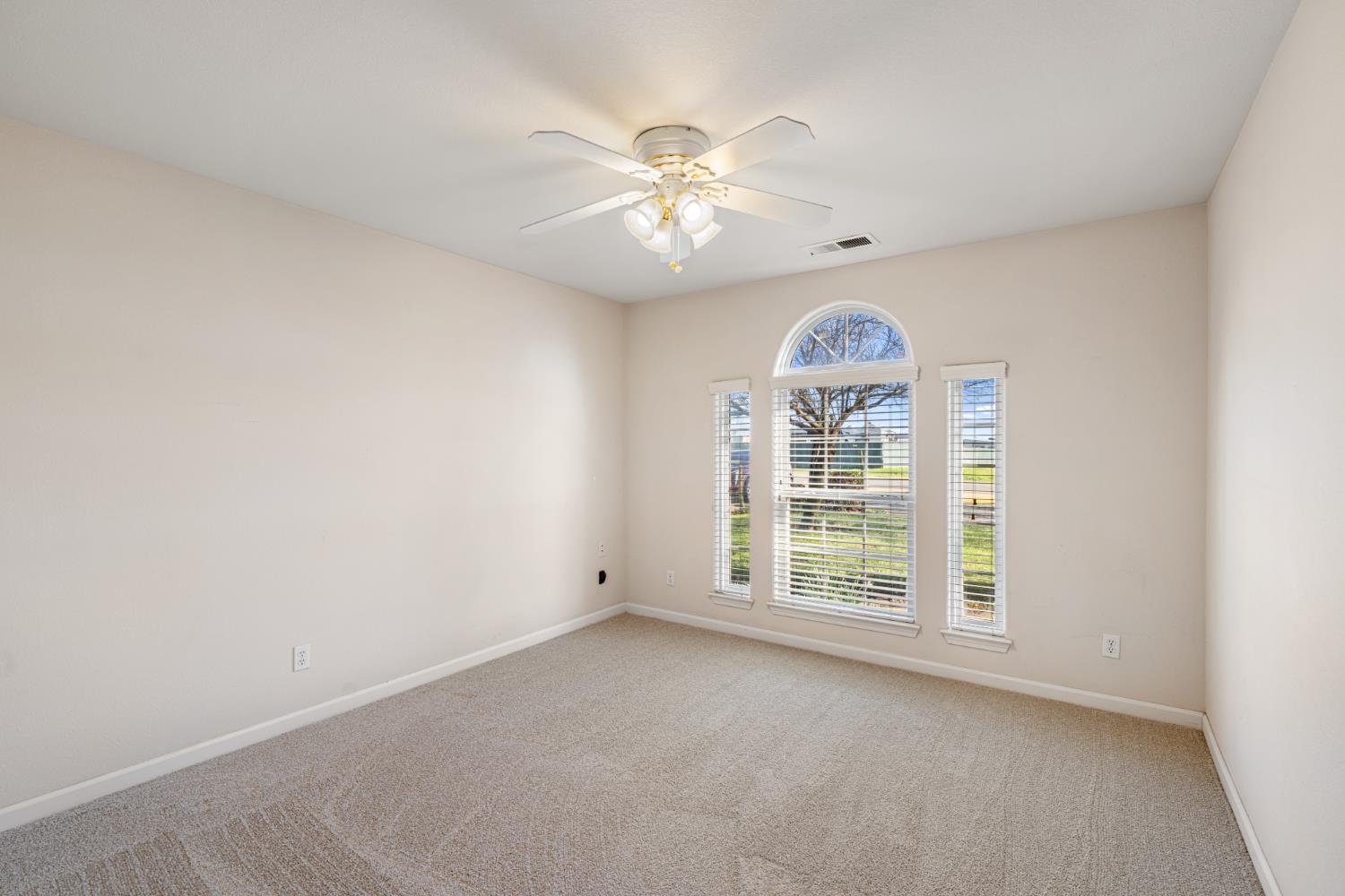 14304 Huntington Road Madera, CA 93636 - Photo 15 of 33 an empty room with windows and ceiling fan