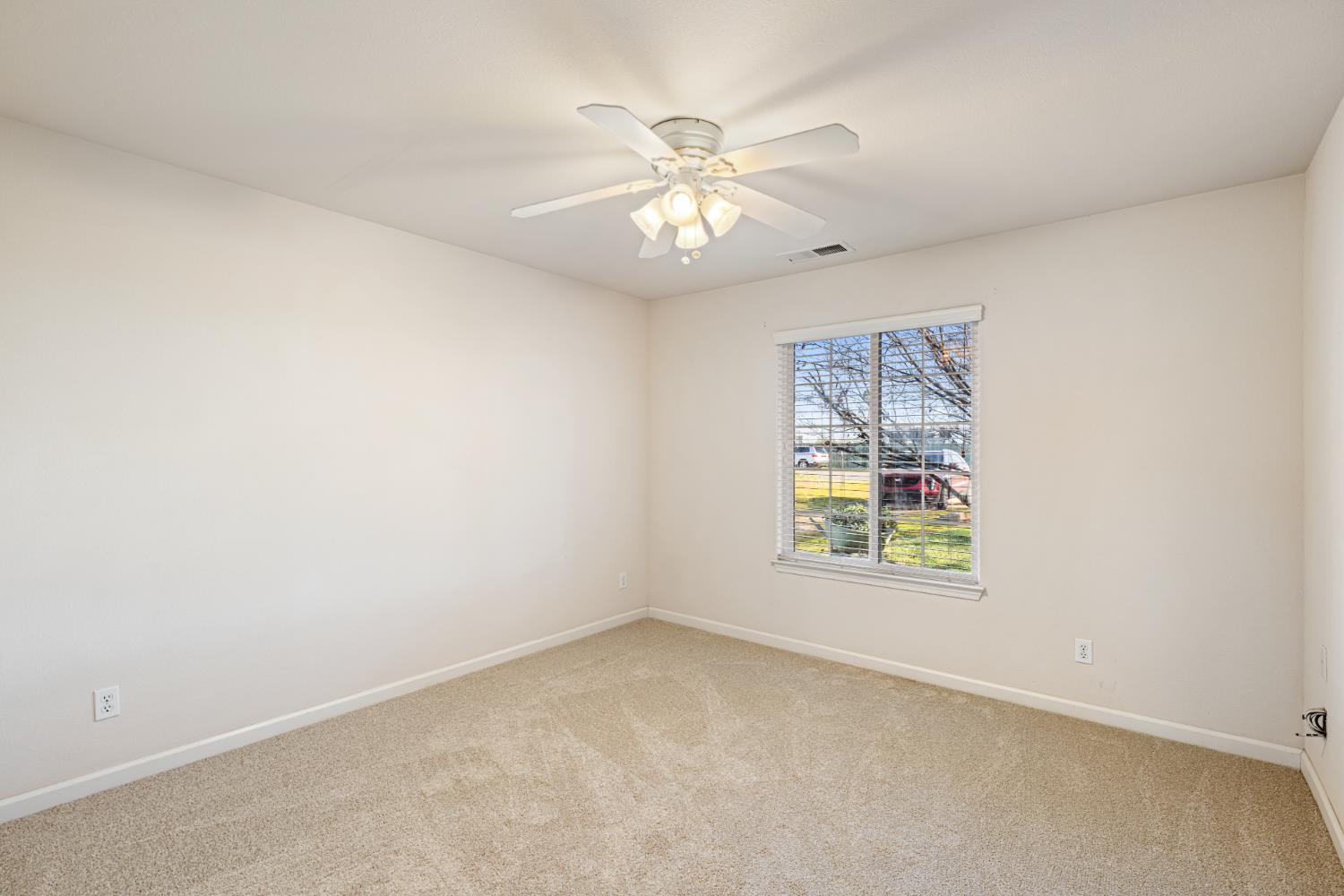 14304 Huntington Road Madera, CA 93636 - Photo 17 of 33 an empty room with a window and a fan