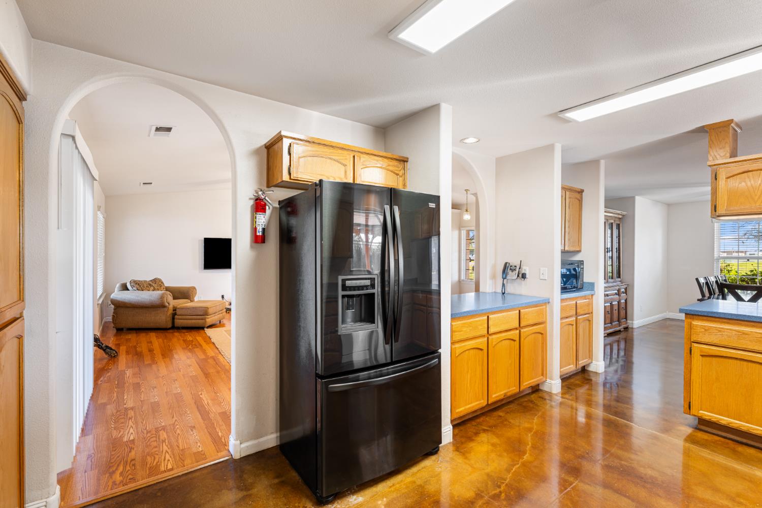 14304 Huntington Road Madera, CA 93636 - Photo 9 of 33 a kitchen with stainless steel appliances a refrigerator and a stove top oven with wooden floor