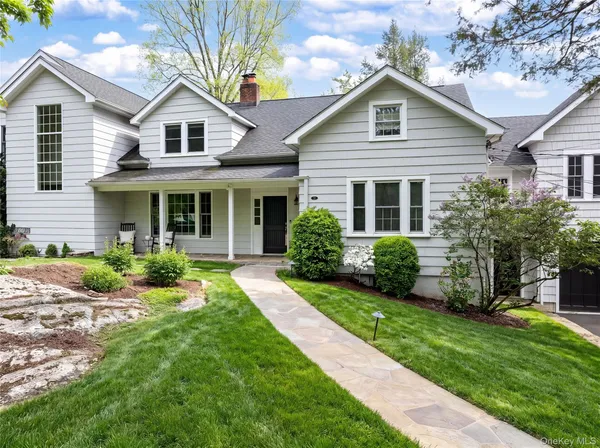 a front view of a house with a yard and potted plants