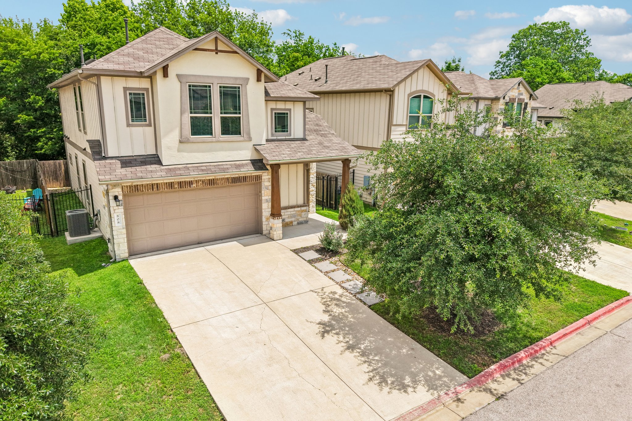 808 Totis Road Austin, TX 78748 - Photo 36 of 40 Contemporary two-story residence featuring a two-car garage, stone and stucco facade, an extended driveway, and mature landscaping