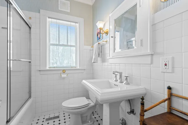 a bathroom with a sink a toilet and a window