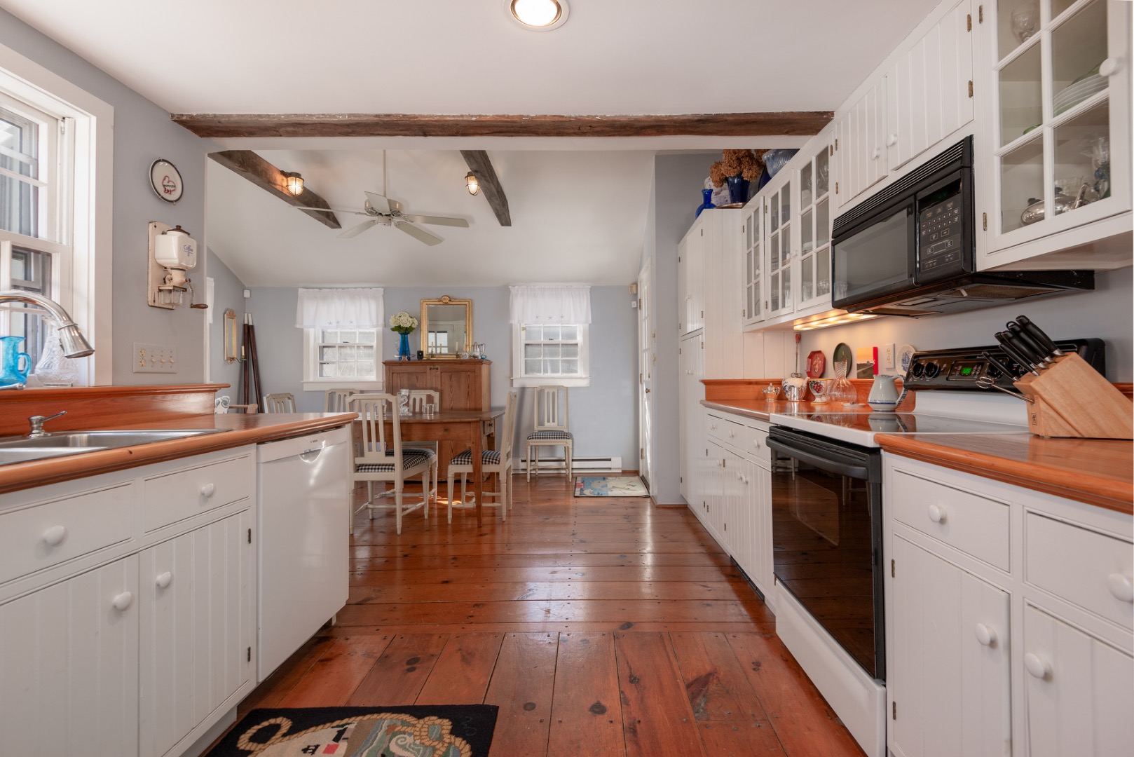 42 North Liberty Street Nantucket, MA 02554 - Photo 10 of 20 a kitchen with stainless steel appliances granite countertop a refrigerator a sink dishwasher a stove and white cabinets with wooden floor