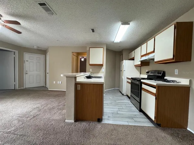 a kitchen with stainless steel appliances granite countertop a stove a sink dishwasher and a refrigerator