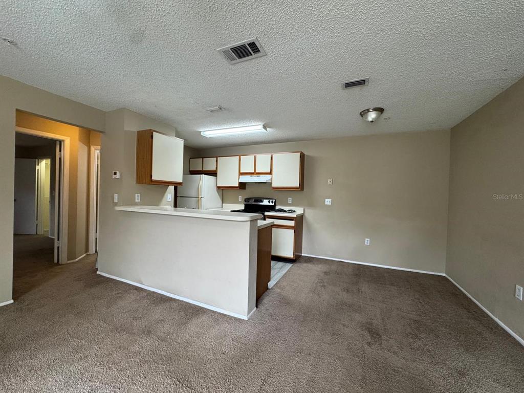 956 Salt Pond Place, Unit 205 Altamonte Springs, FL 32714 - Photo 5 of 15 a kitchen with a refrigerator and white cabinets