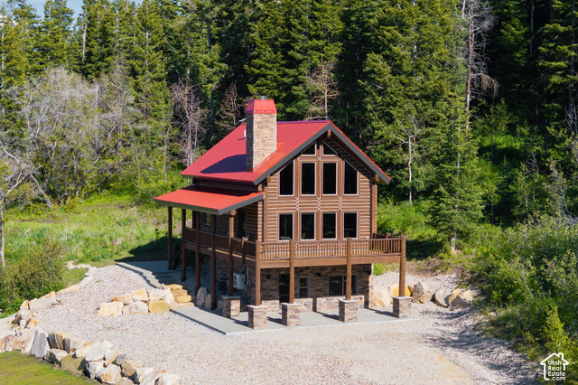 917 West Deep Forest Road Coalville, UT 84017 - Photo 3 of 41 Log-style siding exterior with a red metal roof and a stone chimney