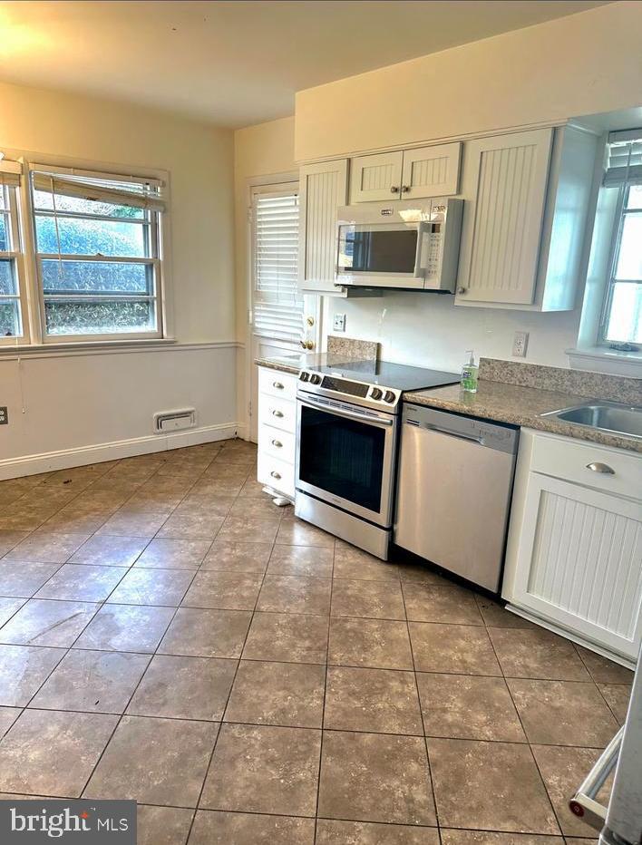 6426 Noble Drive McLean, VA 22101 - Photo 3 of 16 a kitchen with stainless steel appliances granite countertop a stove a sink a granite counter tops and a view of living room