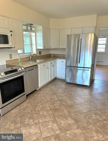 a kitchen with a stove a sink and a refrigerator