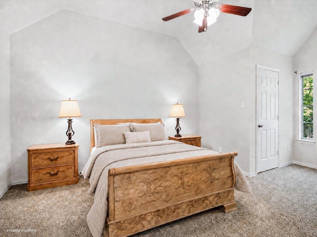 14592 Greenleaf Court Addison, TX 75001 - Photo 15 of 34 Vaulted ceiling bedroom featuring plush carpeting, a multi-pane window, a paneled door, and a ceiling fan with integrated lighting