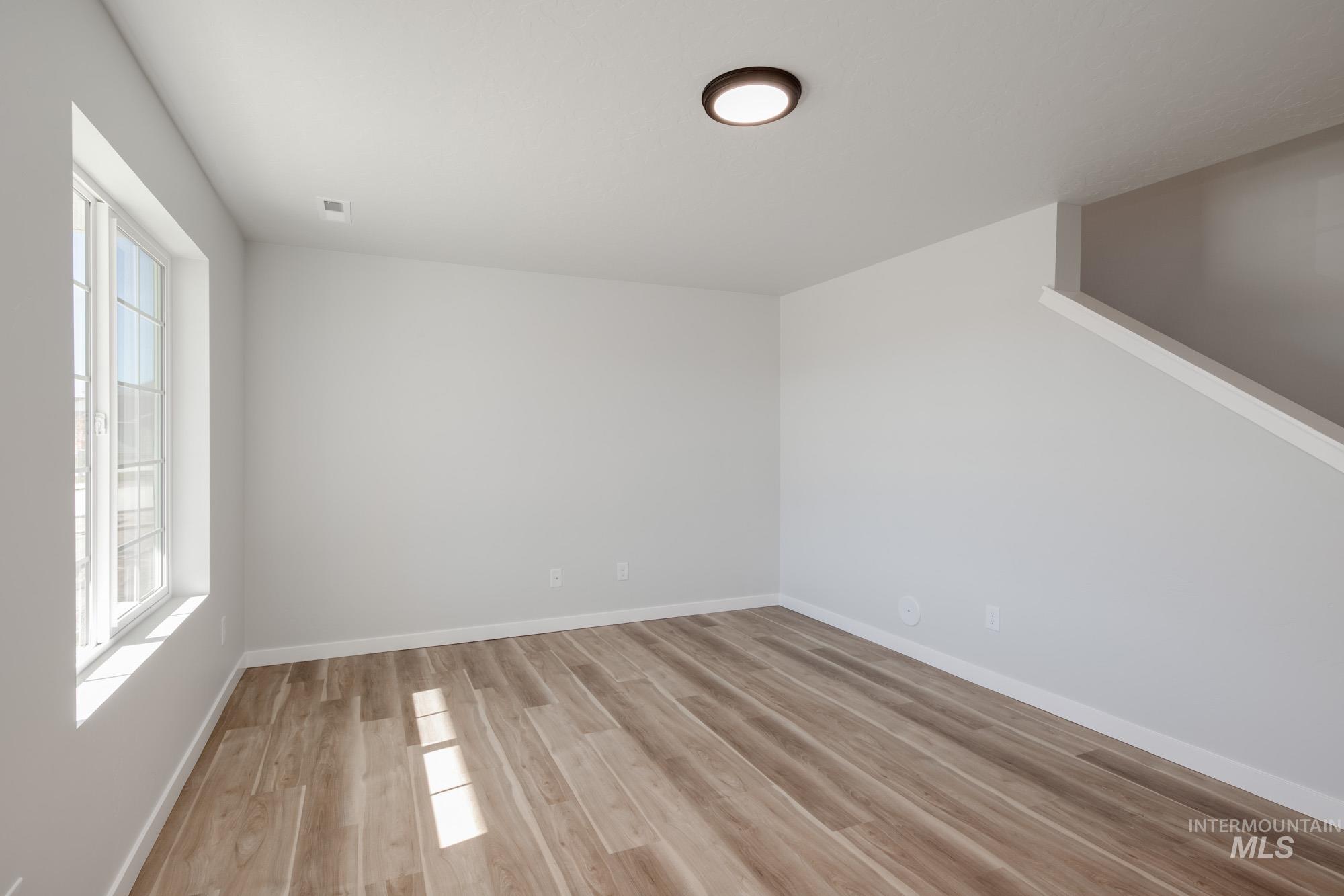 1614 Long Pond Street Middleton, ID 83644 - Photo 12 of 28 Empty room with baseboards and light wood-type flooring