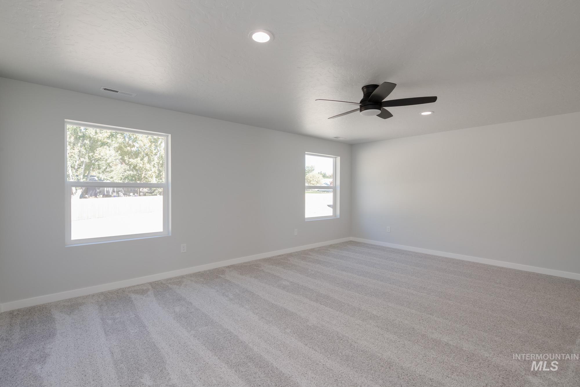 1614 Long Pond Street Middleton, ID 83644 - Photo 18 of 28 Unfurnished room with light colored carpet, recessed lighting, and a ceiling fan