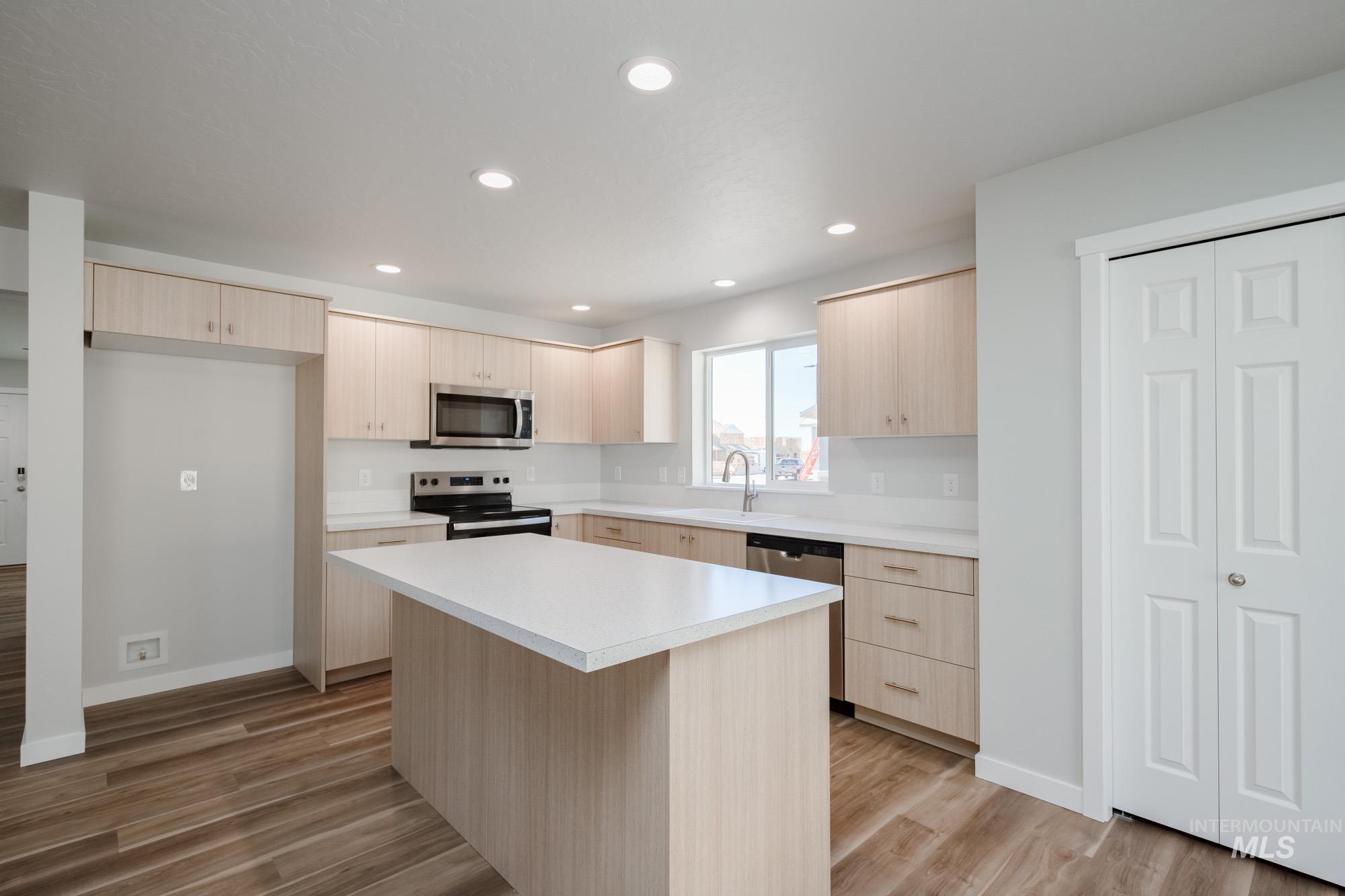 1614 Long Pond Street Middleton, ID 83644 - Photo 5 of 28 Kitchen with light brown cabinets, light countertops, appliances with stainless steel finishes, dark wood-style flooring, and recessed lighting