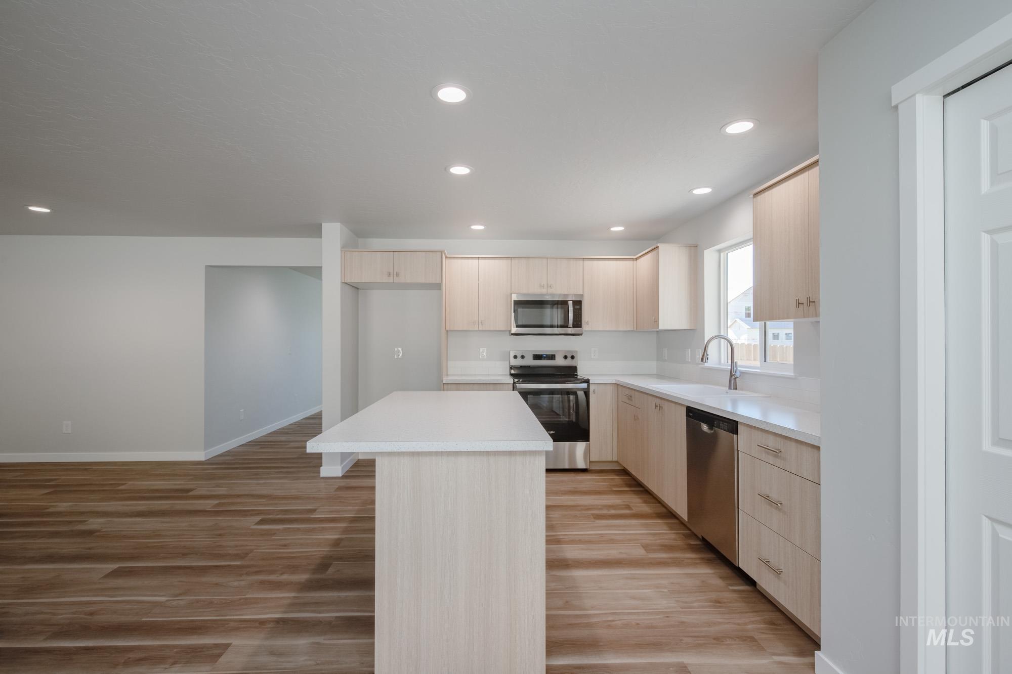1614 Long Pond Street Middleton, ID 83644 - Photo 7 of 28 Kitchen with light brown cabinets, stainless steel appliances, a center island, light wood finished floors, and recessed lighting
