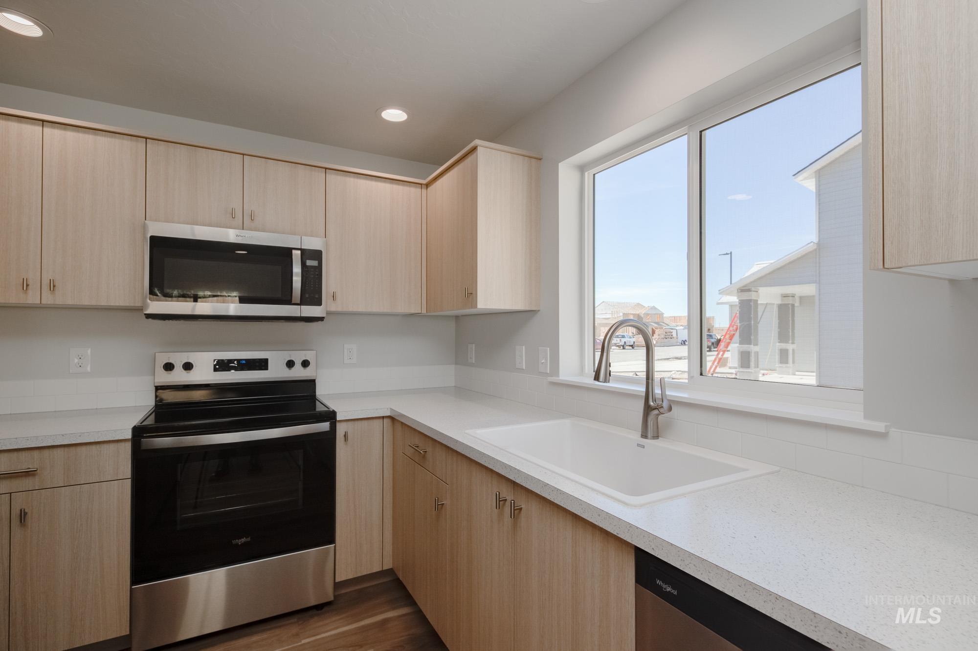 1614 Long Pond Street Middleton, ID 83644 - Photo 8 of 28 Kitchen featuring light brown cabinets, appliances with stainless steel finishes, light countertops, and recessed lighting