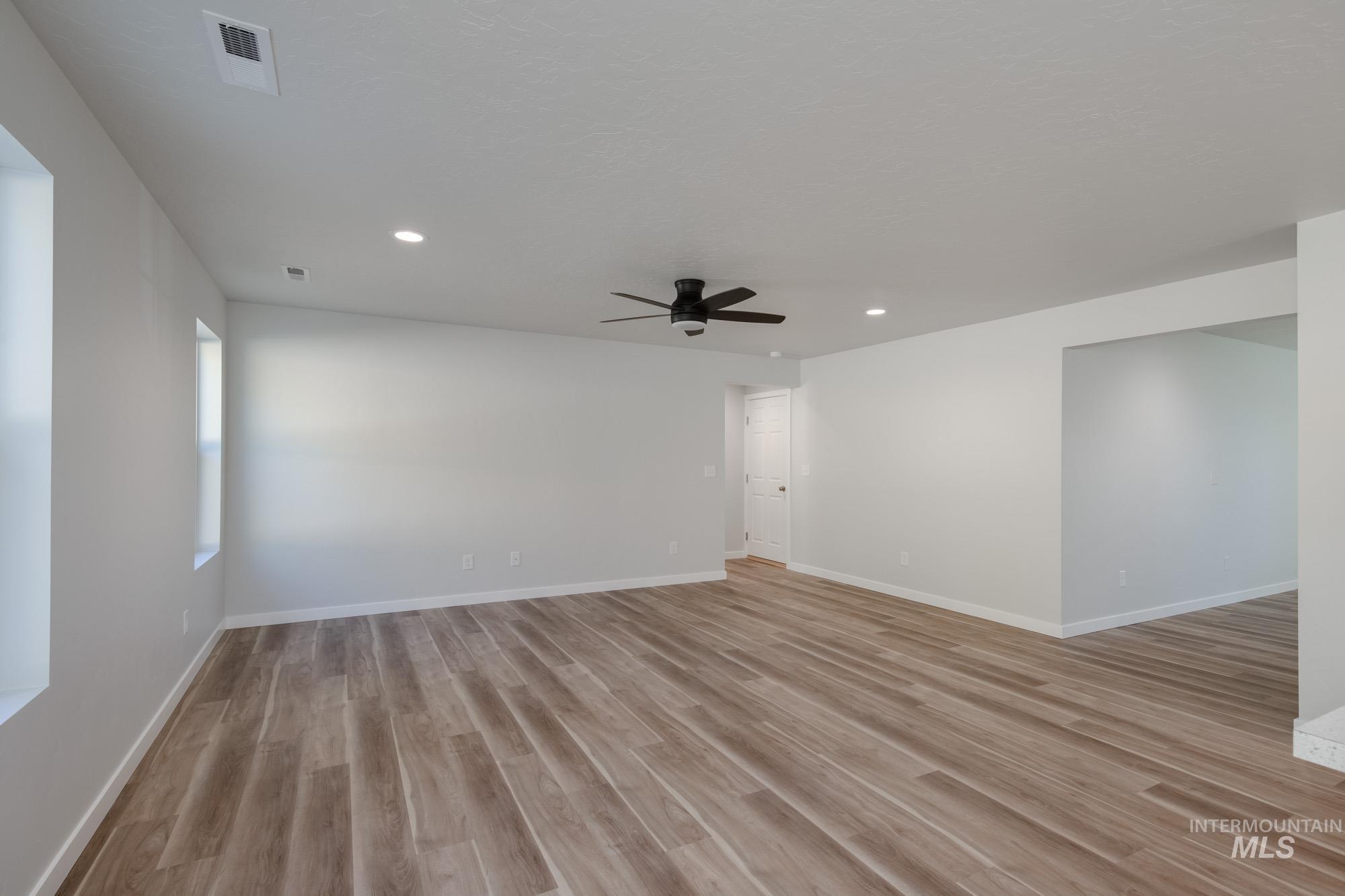 1614 Long Pond Street Middleton, ID 83644 - Photo 10 of 28 Empty room featuring light wood finished floors, recessed lighting, and ceiling fan