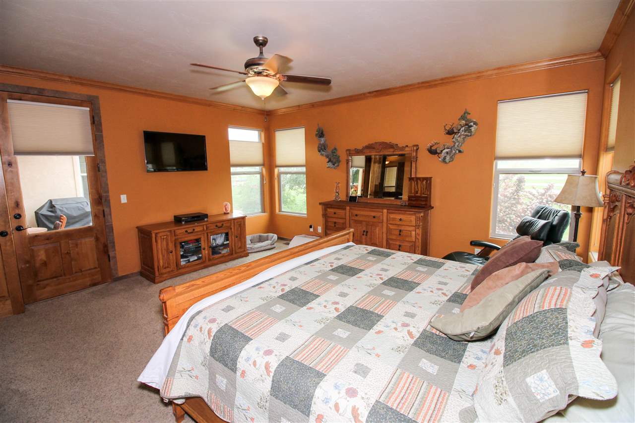 1114 22 Road Grand Junction, CO 81505 - Photo 12 of 26 a bed room with a bed mirror and a chandelier