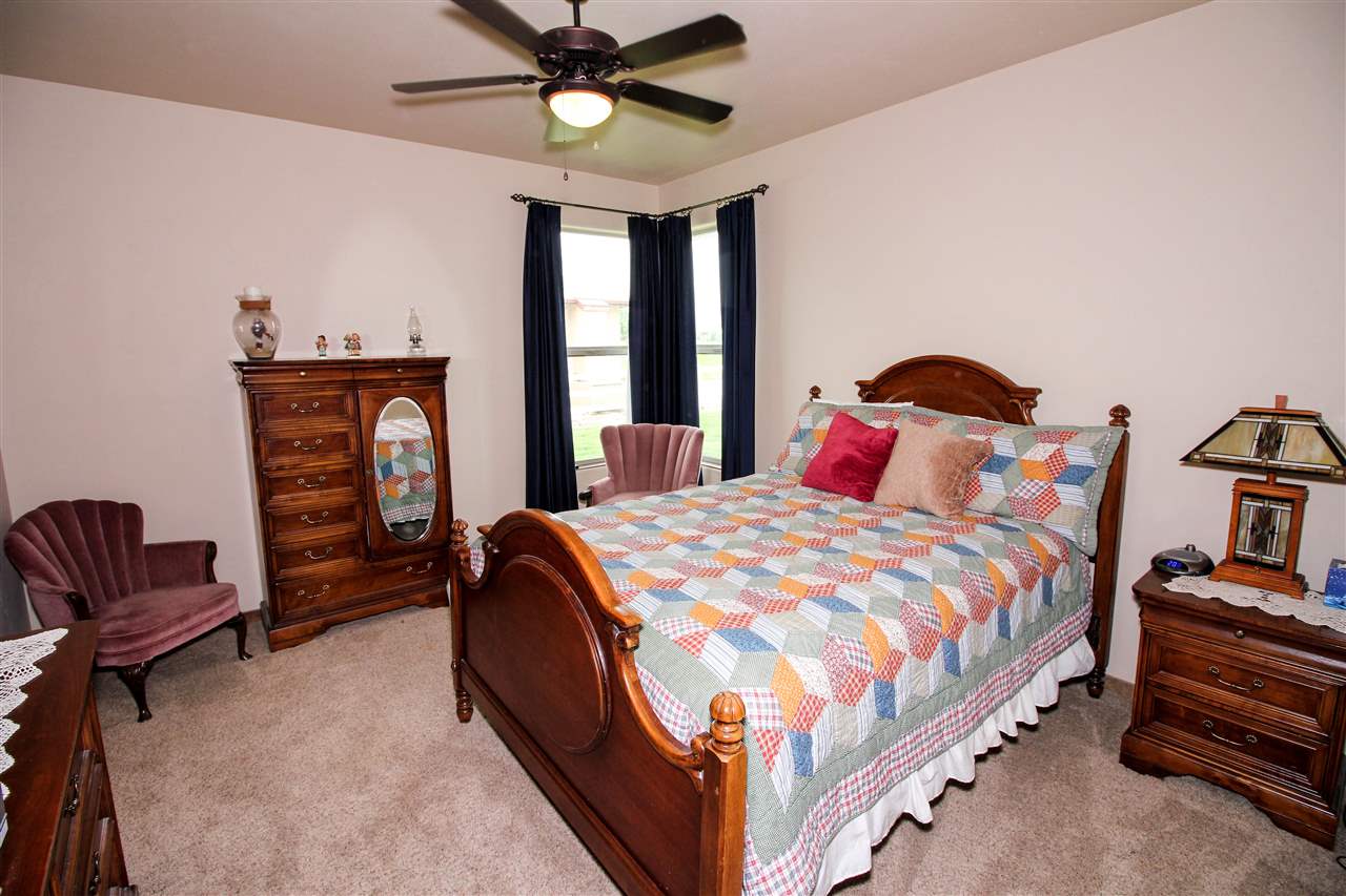 1114 22 Road Grand Junction, CO 81505 - Photo 16 of 26 a bedroom with a bed and a chandelier