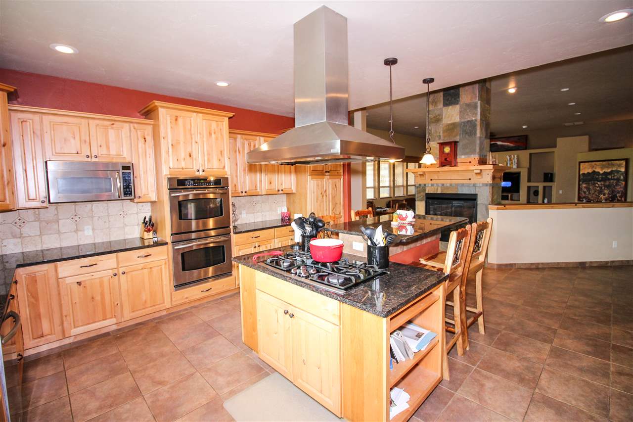 1114 22 Road Grand Junction, CO 81505 - Photo 7 of 26 a kitchen with stainless steel appliances kitchen island granite countertop a stove a sink and a refrigerator