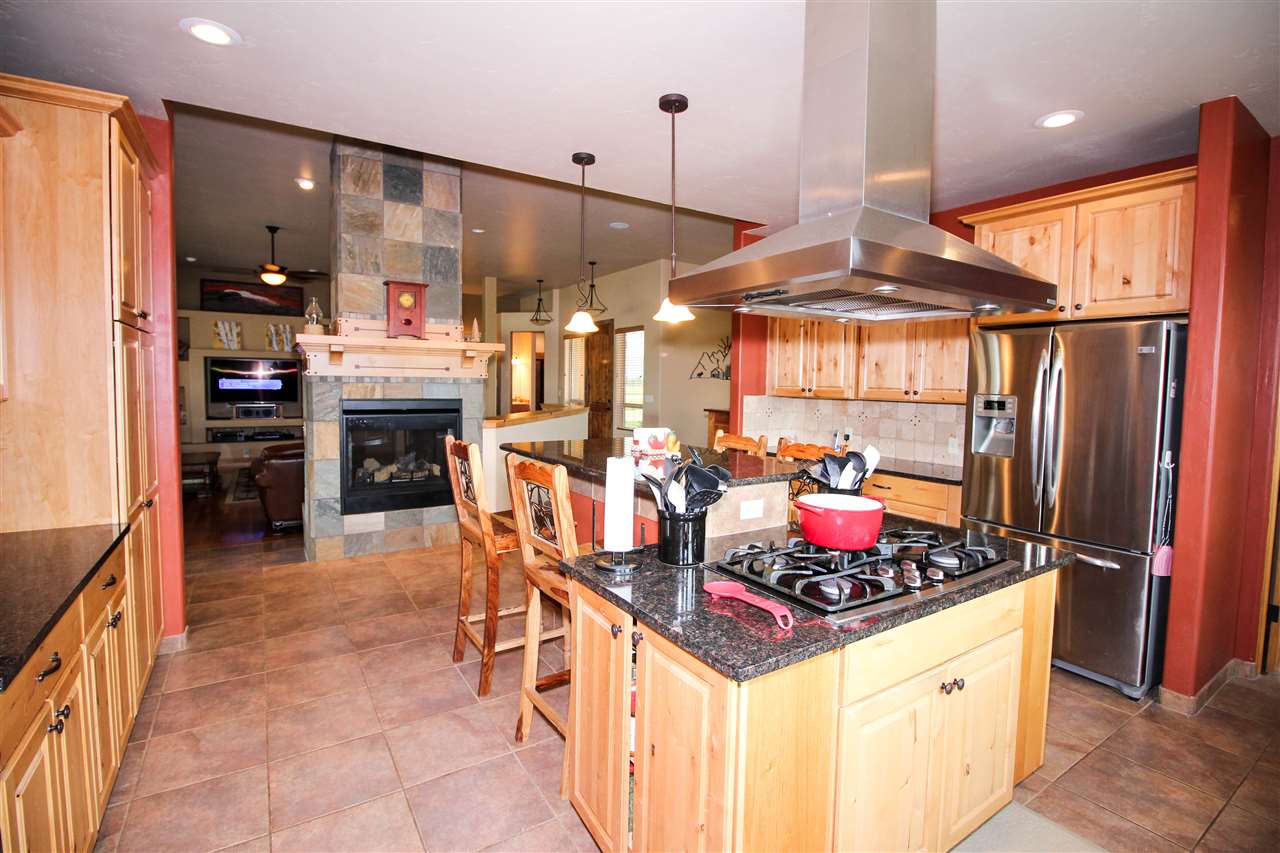 1114 22 Road Grand Junction, CO 81505 - Photo 8 of 26 a kitchen with stainless steel appliances kitchen island granite countertop a stove and a refrigerator