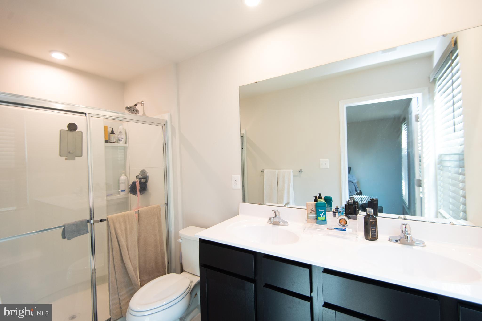 112 Mariners Way Cambridge, MD 21613 - Photo 15 of 29 a bathroom with a sink a toilet a mirror and shower