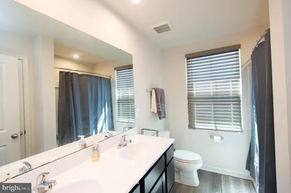 a bathroom with a sink a toilet and large mirror