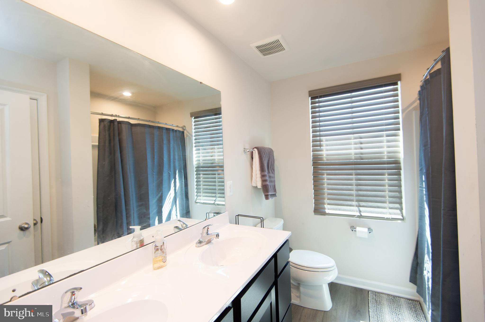 112 Mariners Way Cambridge, MD 21613 - Photo 23 of 29 a bathroom with a sink a toilet and large mirror