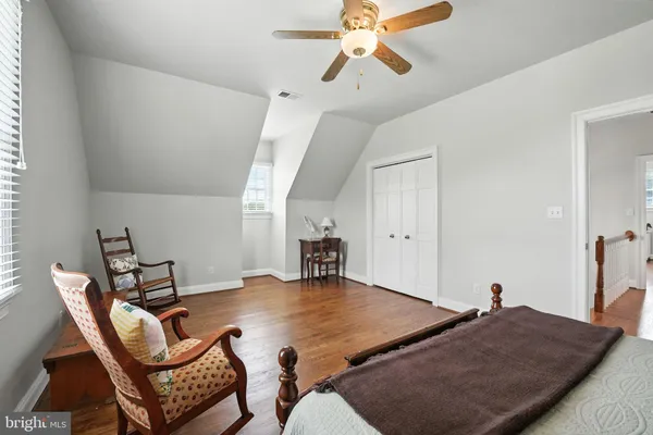 a living room with furniture a fireplace and a dining table with wooden floor