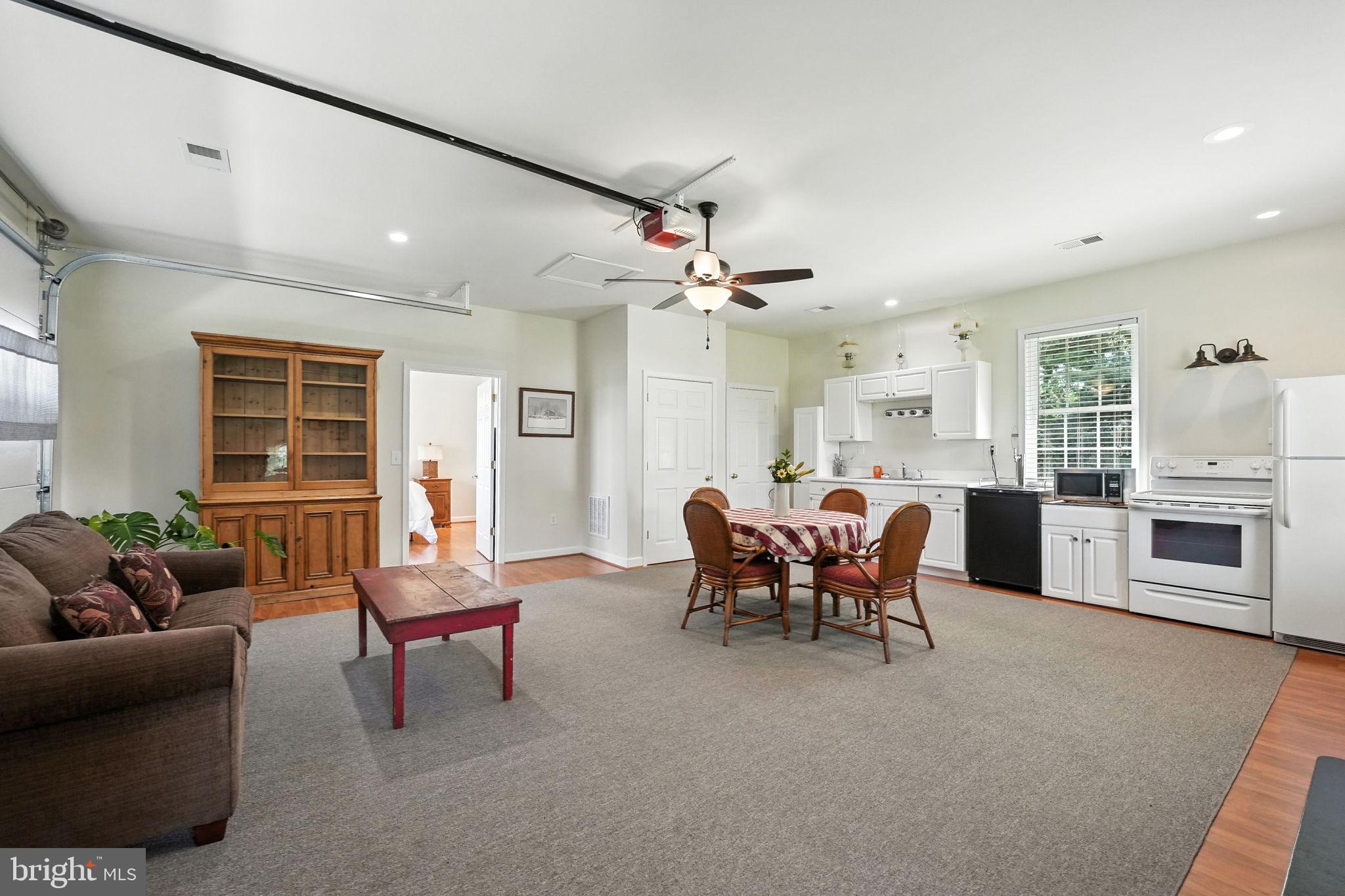 12564 Eggbornsville Road Culpeper, VA 22701 - Photo 55 of 62 a living room with furniture a fireplace and a dining table with wooden floor