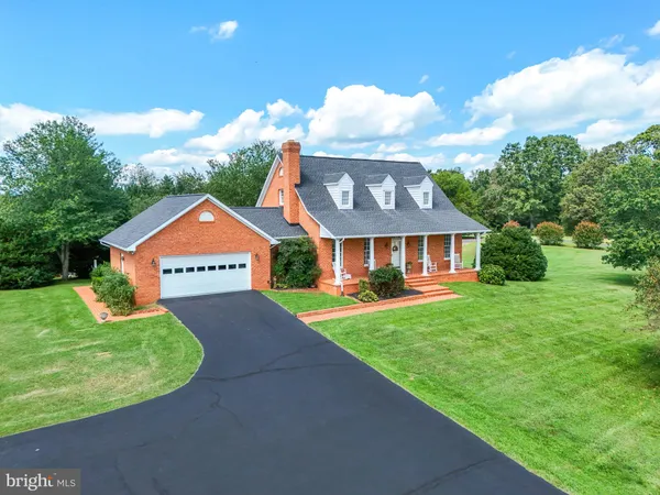 a view of a house with a yard and a large tree