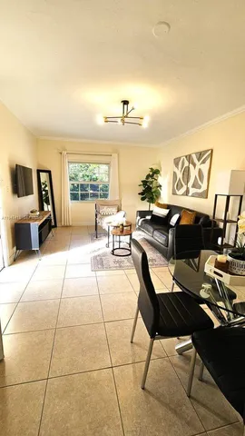 a living room with furniture a rug and a floor to ceiling window