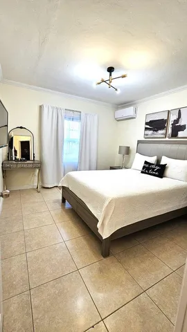 a bedroom with a bed a mirror and window