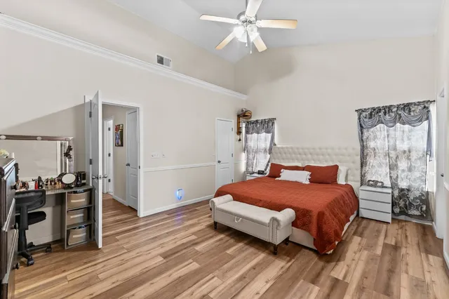 a bedroom with a bed and wooden floor