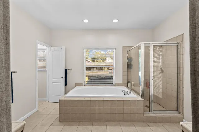 a spacious bathroom with a tub shower and window