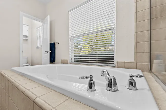 a bathroom with a tub sink and mirror