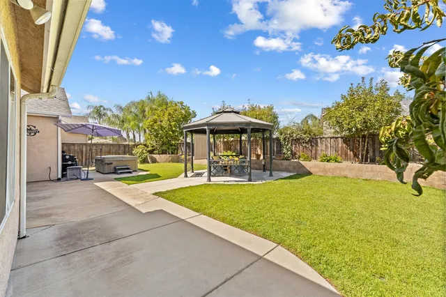 a view of a patio with table and chairs under an umbrella