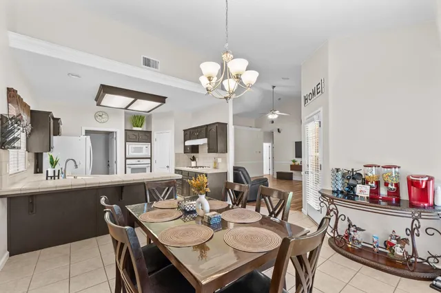a view of a dining room with furniture and a chandelier