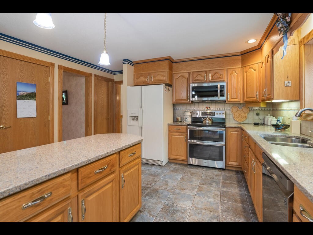 20 Paradise Lake Road Monson, MA 01057 - Photo 25 of 42 a kitchen with kitchen island granite countertop a stove top oven microwave and refrigerator